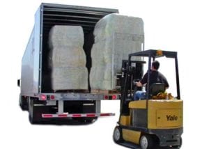 forklift unloading footing bales from truck