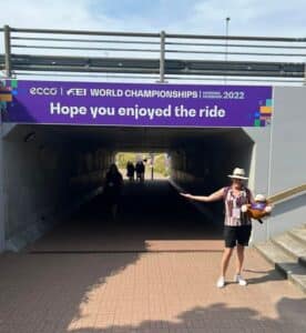 Woman in front of world equestrian championship banner
