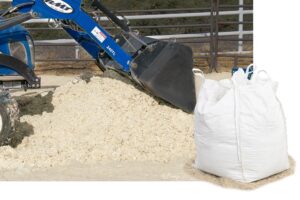 blue tractor moving pile of sand