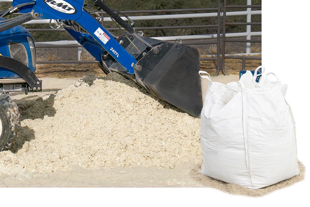 blue tractor moving pile of sand
